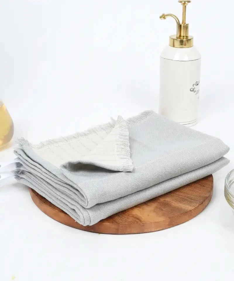 Stack of grey towels on a wooden board in the background.