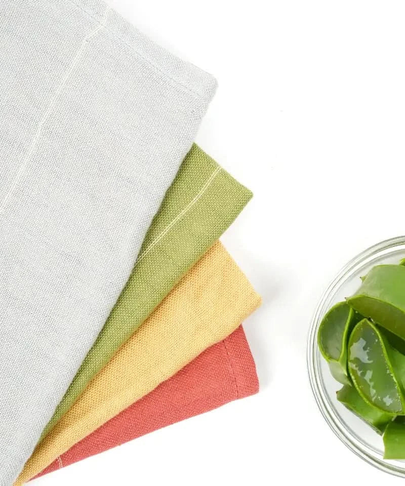 Set of aloevera towels with a small bowl of aloe vera pieces on a white background