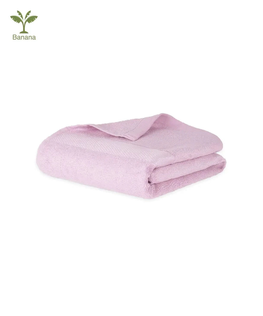 Folded barely pink Banana super light terry bath towel on a white background with .