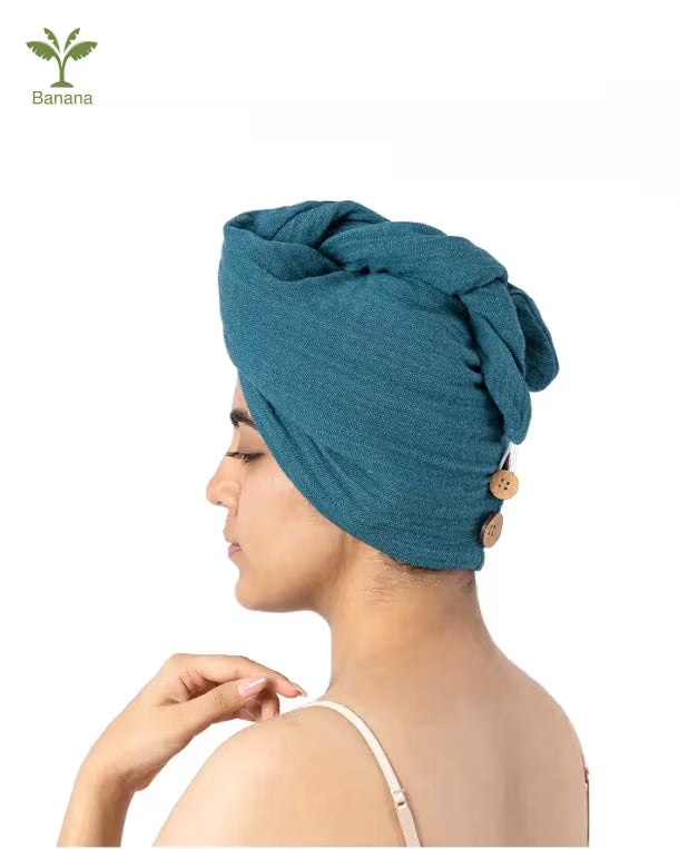 Woman wearing a dutch teal - banana double cloth hair towel wrap with buttons on a white background