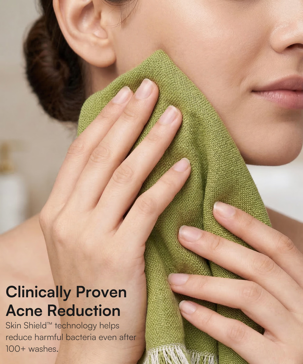 Close-up of woman gently pressing a green Doctor Towels face towel against her cheek.