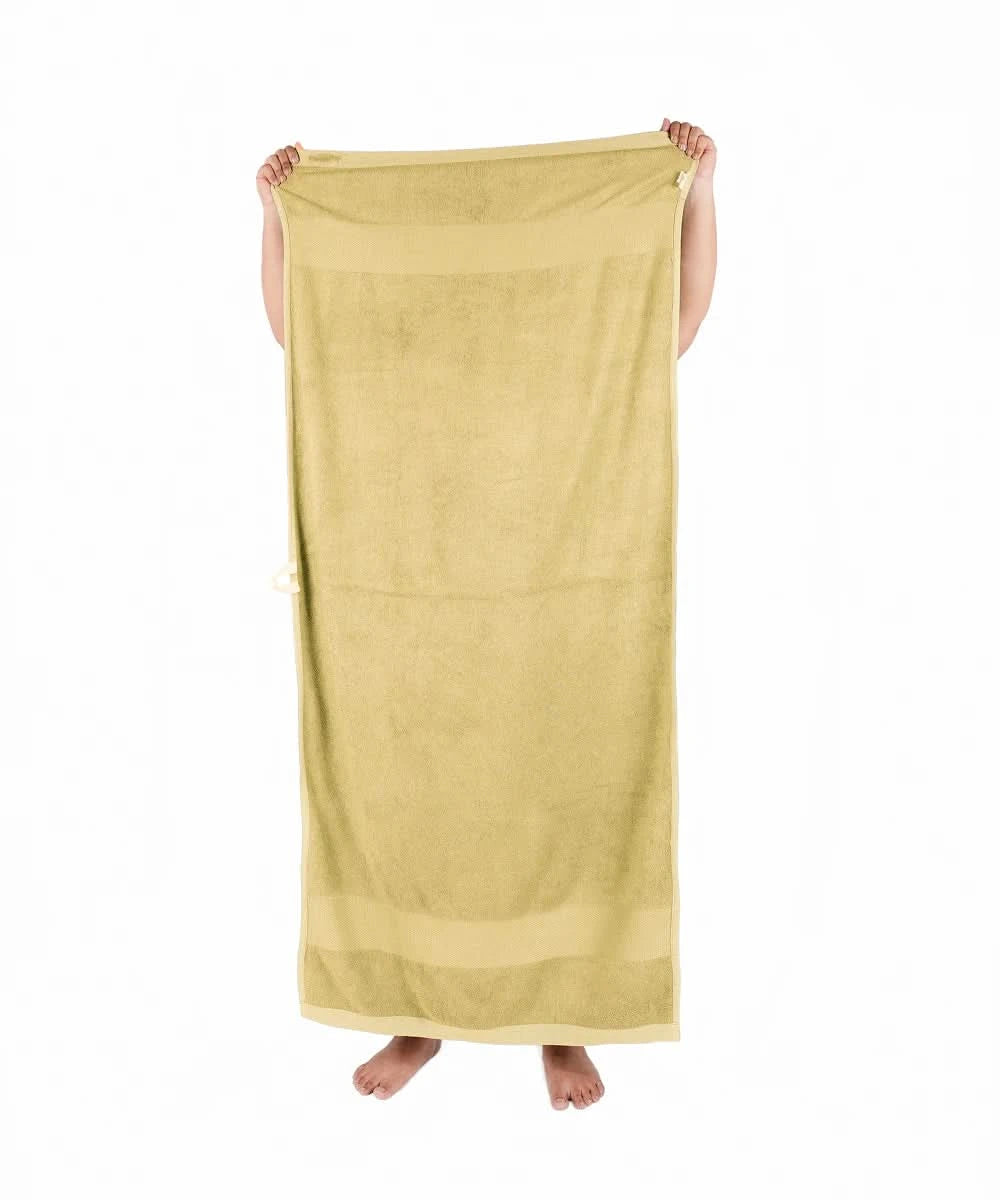 Person holding a yellow towel against a white background