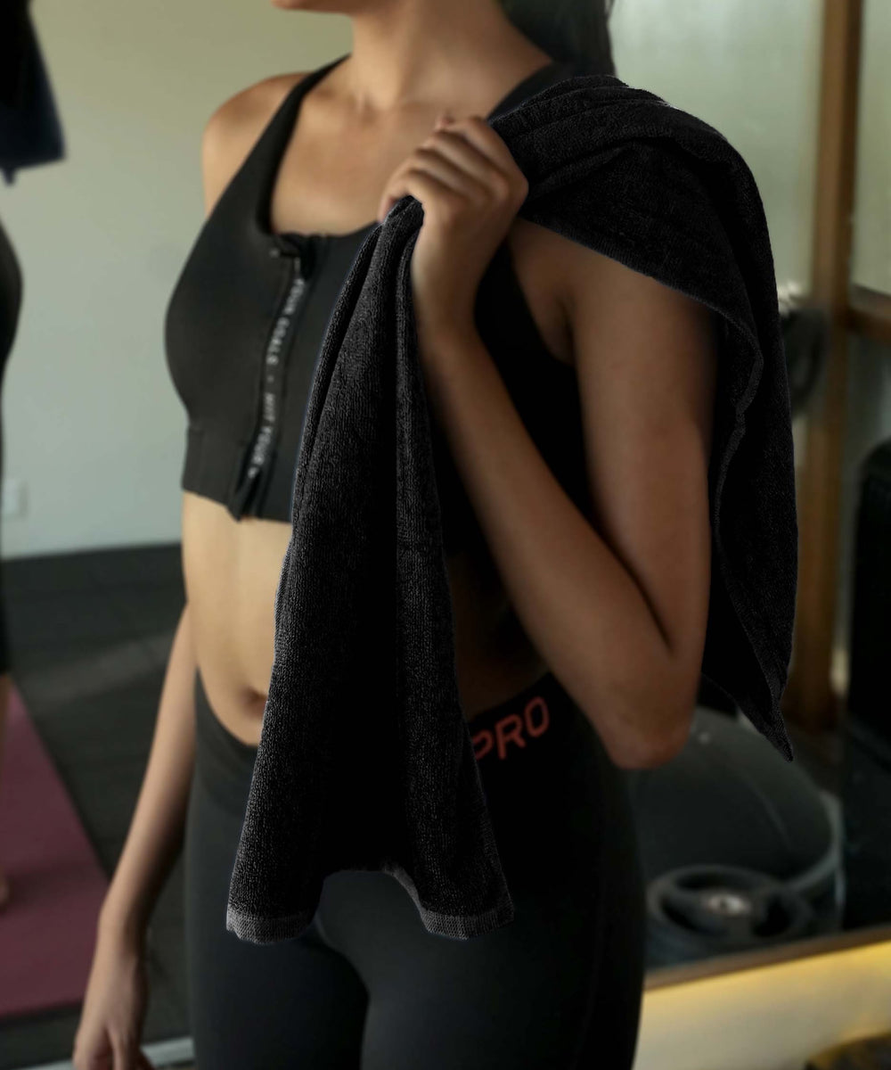 Person holding a banana terry gym towel with in a gym setting
