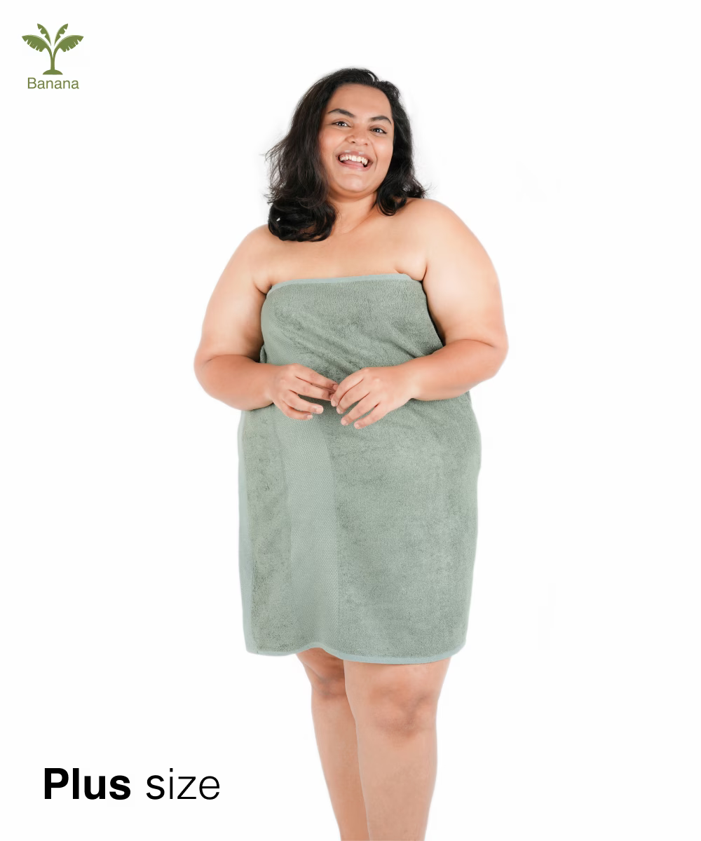 Woman wearing a green plus-size towel wrap on a white background