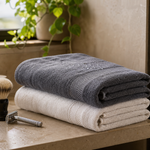 Folded towel beside shaving tools in a bright bathroom