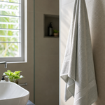 Light bath towel hanging in a compact sunlit bathroom with airy drying setup