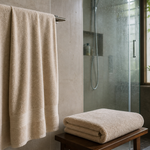 A full-size bath towel hanging neatly in a bright Indian bathroom with another folded large towel nearby