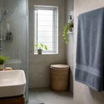 Soft bathroom towel hanging in a compact humid bathroom with daylight