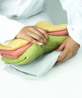 Person holding a stack of colorful folded cloths on a white background