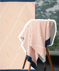 Geometric patterned towel draped over a chair with a blurred background