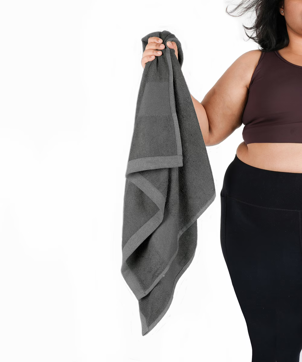 Person holding a grey towel with a white background