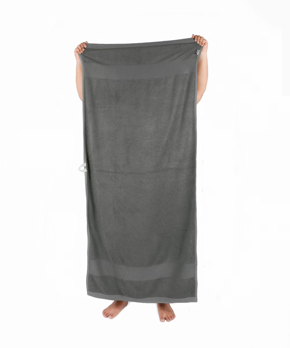 Person holding a grey towel on a white background