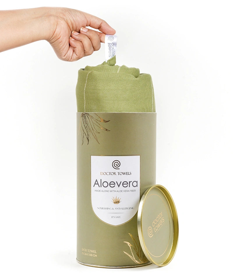 Aloe vera towel in a cylindrical container with a hand lifting a towel from it.
