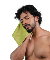Man with a green face towel on a white background