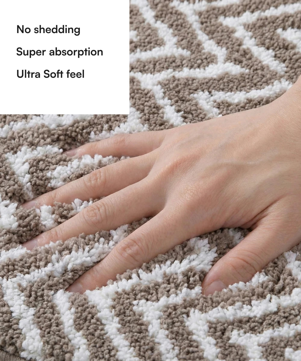 Textured brown and white bath mat with a hand touching it, highlighting features like no shedding, super absorption, and ultra soft feel.