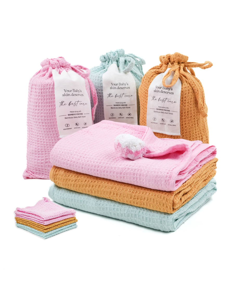 Baby care products including folded towels and small bags on a white background