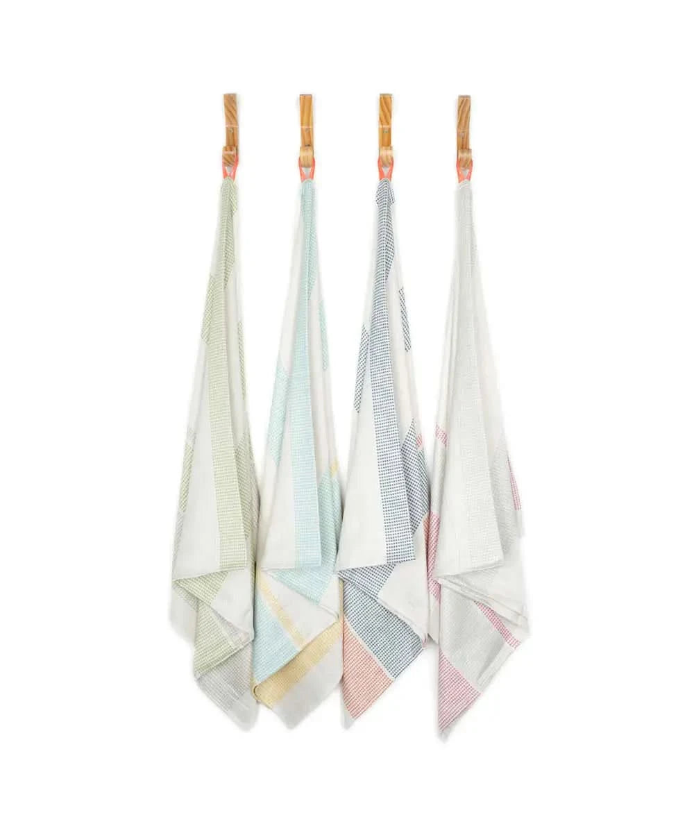 Set of four colorful bamboo dobby towels hanging on a line against a white background.