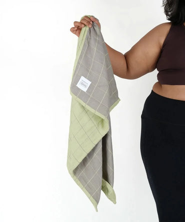 Person holding a Banana Double Cloth plus size bath towel on a white background