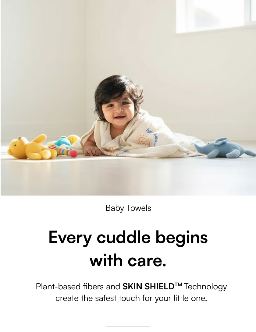 Child lying on a white surface with toys, wearing a baby towel, and text about baby towels and care.