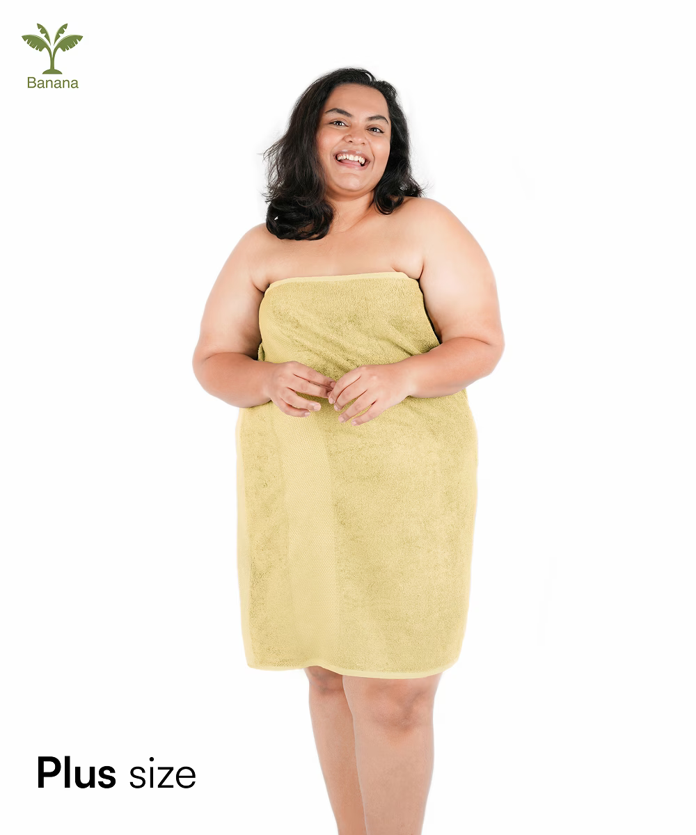 Woman wrapped in a yellow towel with 'Plus size' text and Banana icon.