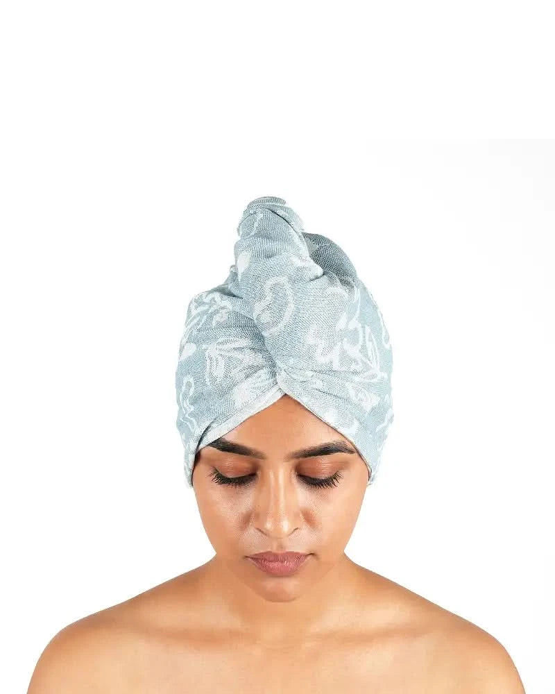Woman wearing a chalk blue- banan floral hair towel on a white background