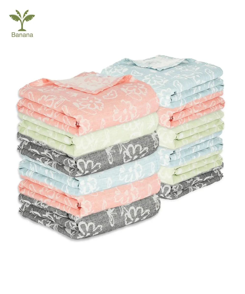 Stack of folded Banana Jacquard Floral Towel with various patterns on a white background.