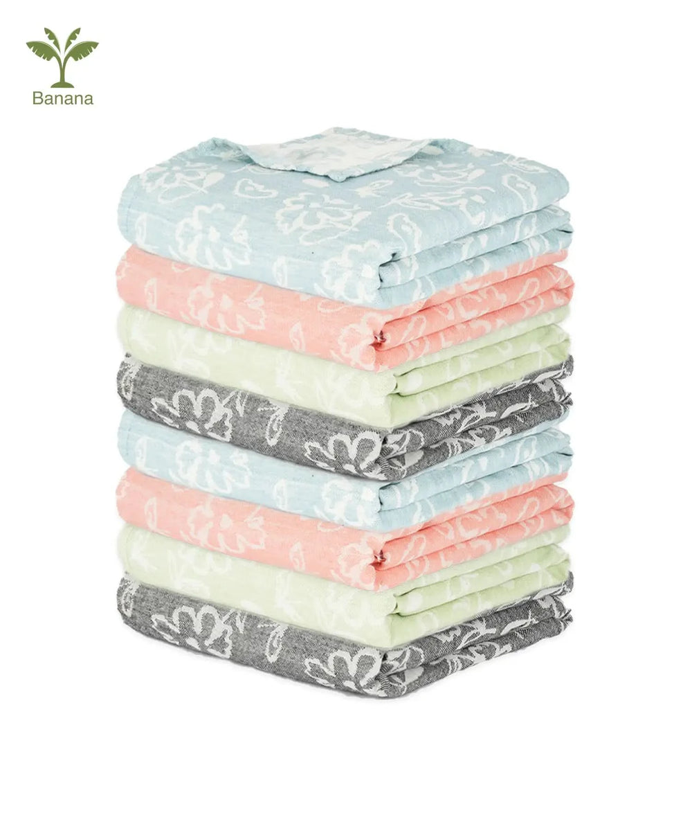 Stack of folded Banana Jacquard Floral Bath towels 8 pieces with various patterns and colors on a white background.