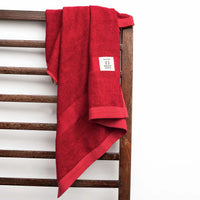 Red towel draped over a wooden ladder with a white background