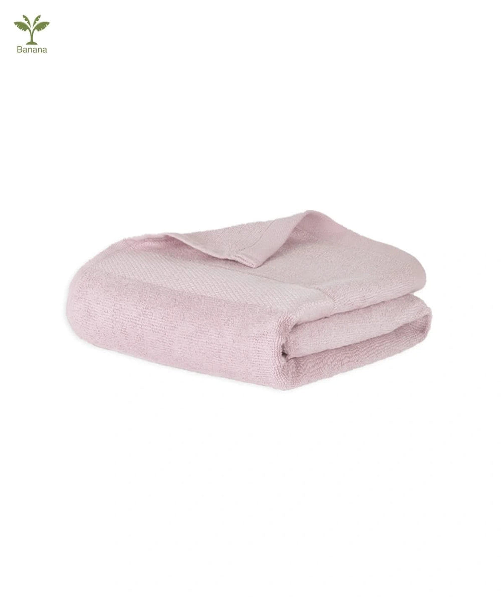 Folded barely pink towel on a white background.