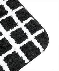 Close-up of a black and white checkered patterned bath mat.