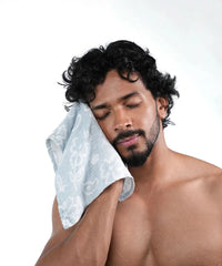 Man with a towel on his shoulder against a white background
