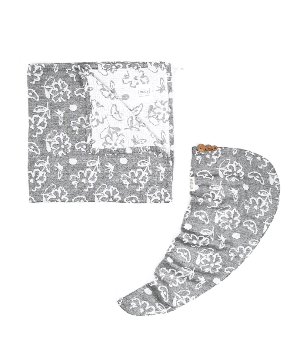 Charcoal grey bath and hair towel with white floral pattern on a white background