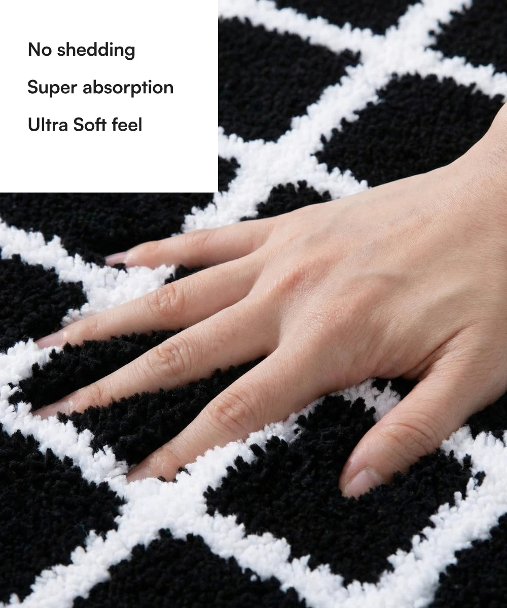 Black and white checkered bath mat with a hand touching it, highlighting features like no shedding, super absorption, and ultra soft feel.