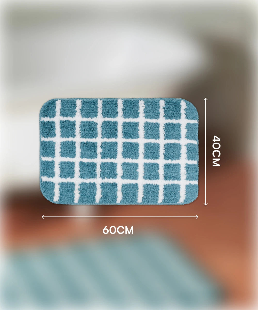 Blue checkered bath mat with dimensions 60cm x 40cm on a blurred background