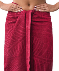 Red patterned towel wrapped around a person on a white background