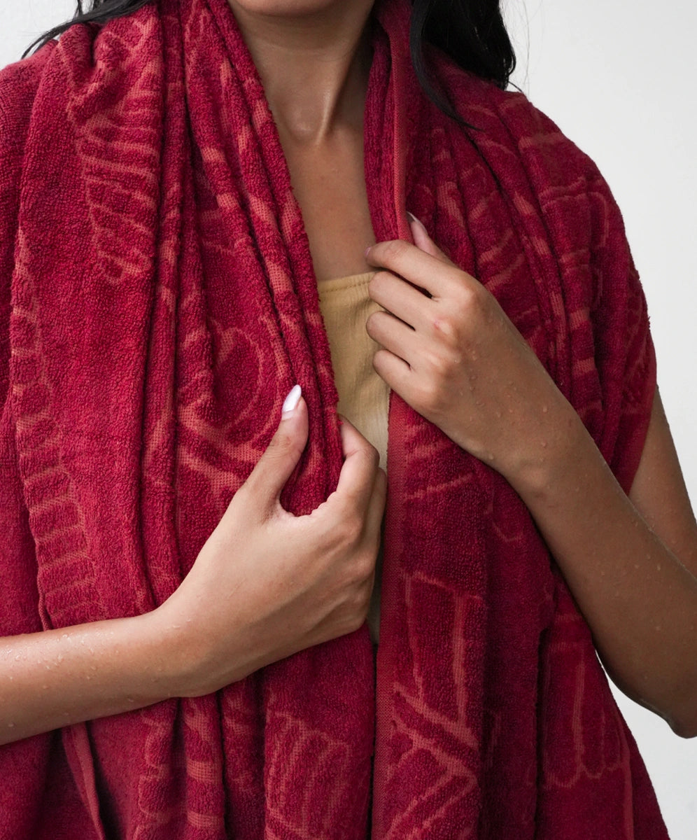 Person wearing a red patterned scarf with a plain background