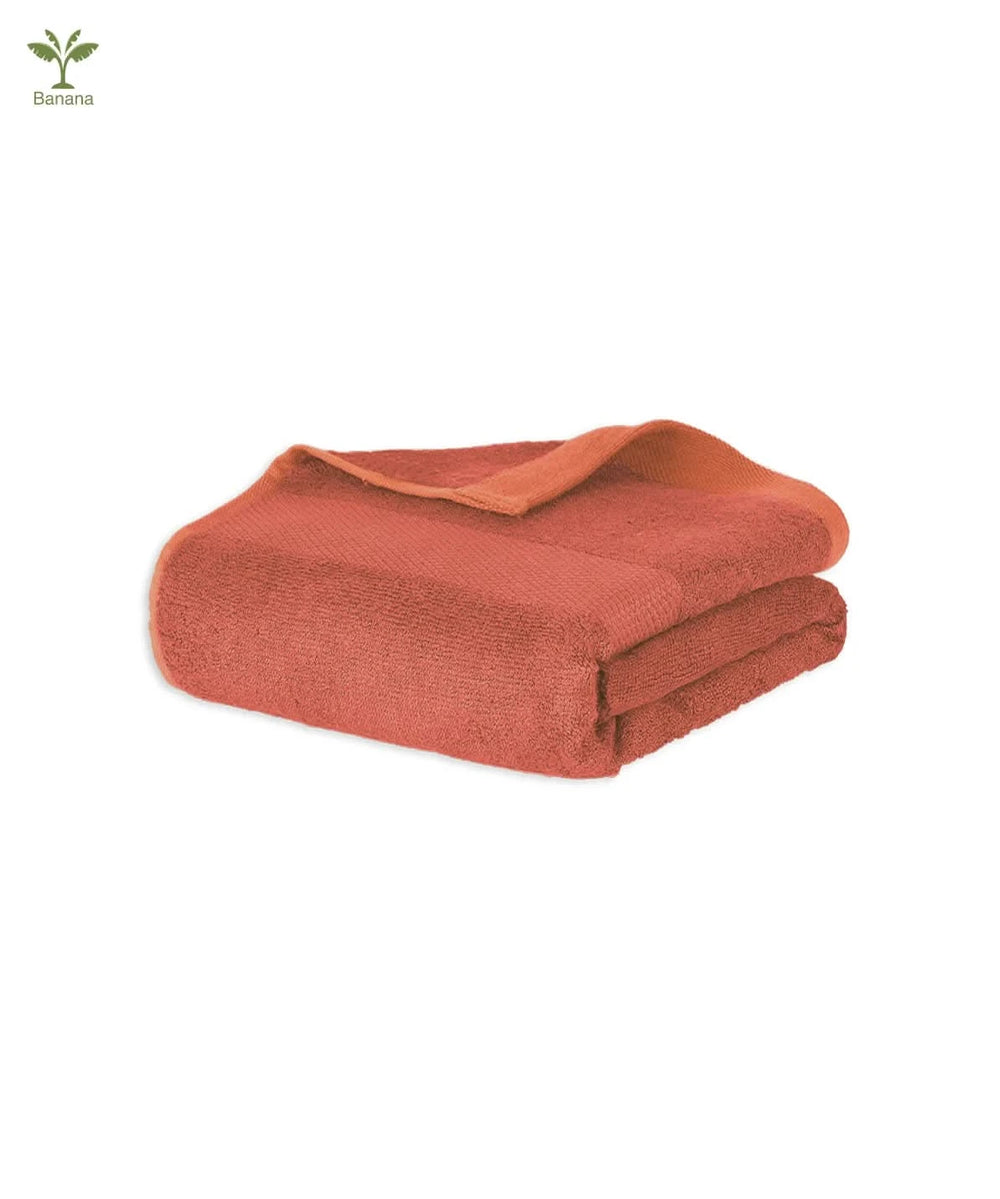 Folded terracotta-colored blanket on a white background