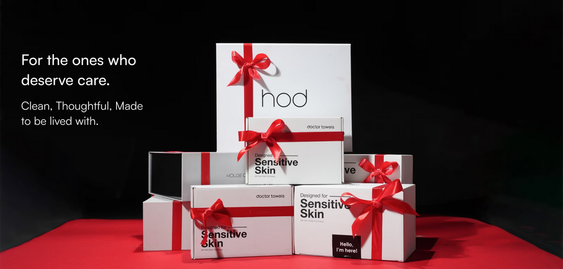 Stack of 'hod' skincare product boxes with red ribbons on a red surface and black background for the Christmas Season. 