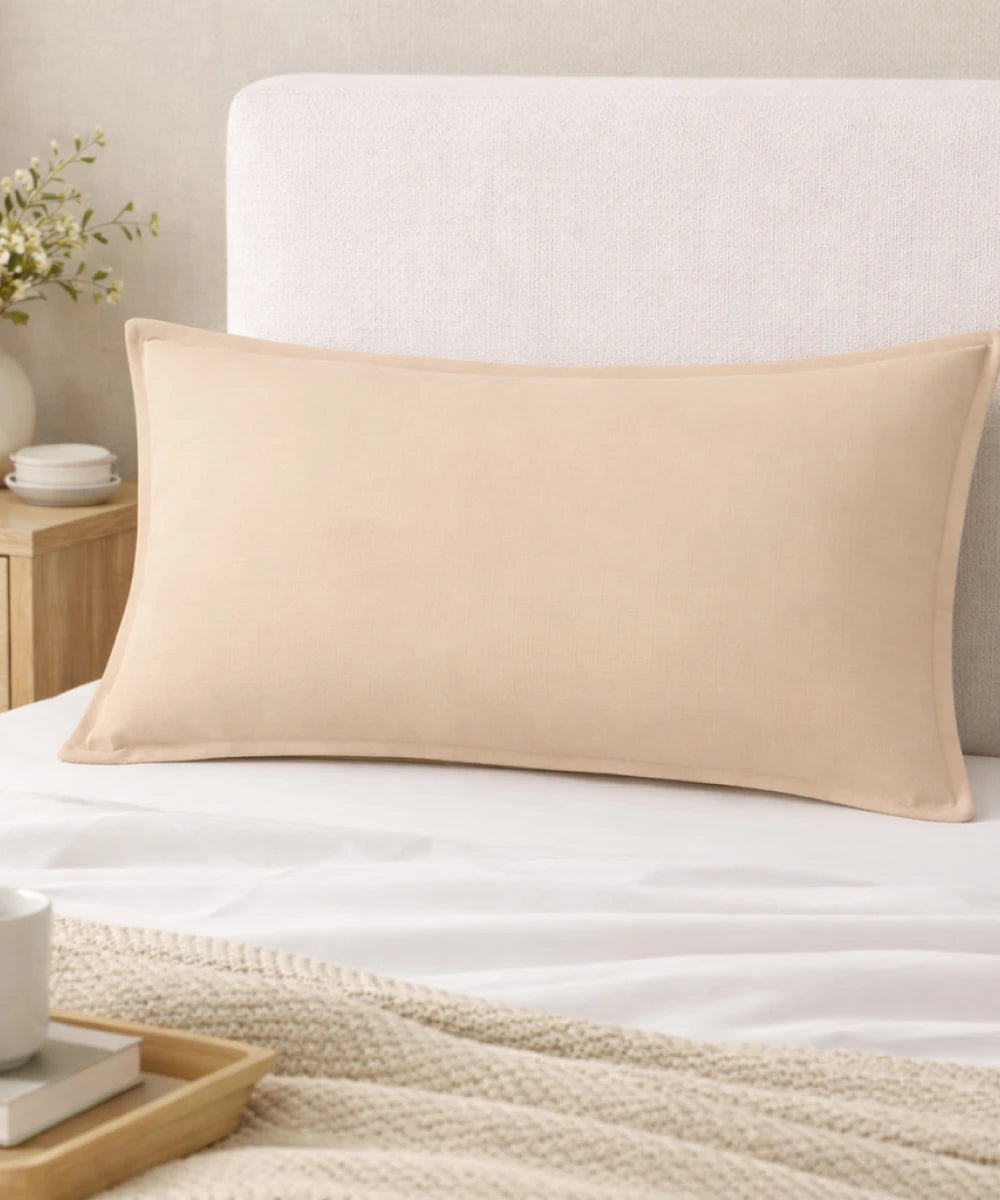 Frozen Dew pillow on a bed with a neutral headboard and side table.