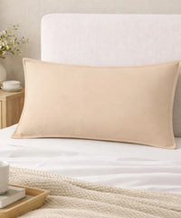 Frozen Dew pillow on a bed with a neutral headboard and side table.