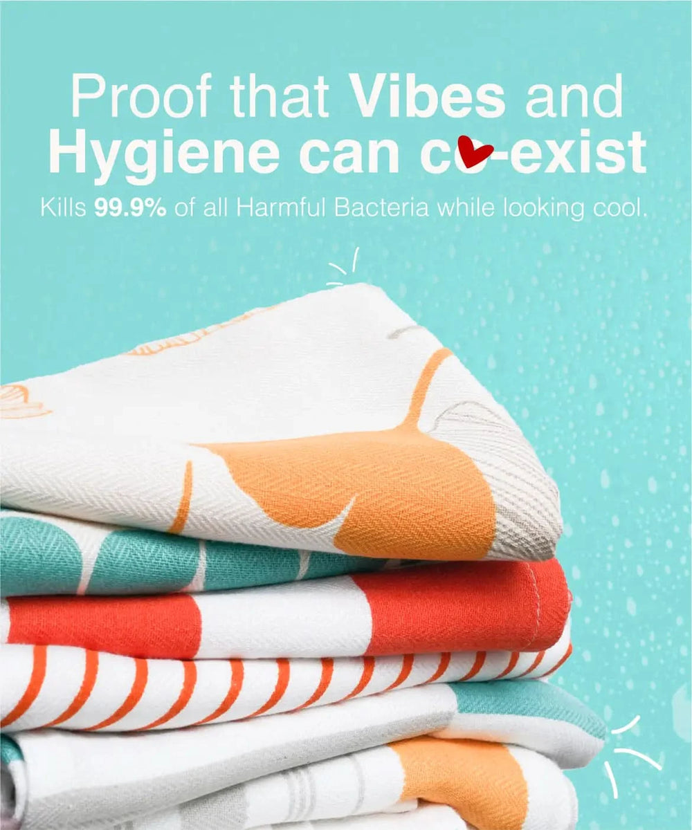 Stack of colorful towels with text about hygiene and bacteria-killing properties on a light blue background.