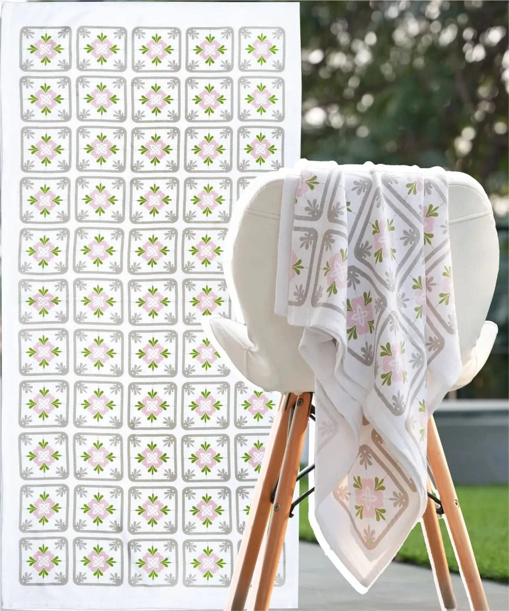 White towel with floral pattern on a wooden stand, next to a sheet of matching decorative stickers.