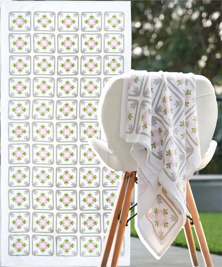 White towel with floral pattern on a wooden stand, next to a sheet of matching decorative stickers.