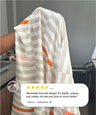 Person holding a patterned towel with a five-star rating and review on a gray background