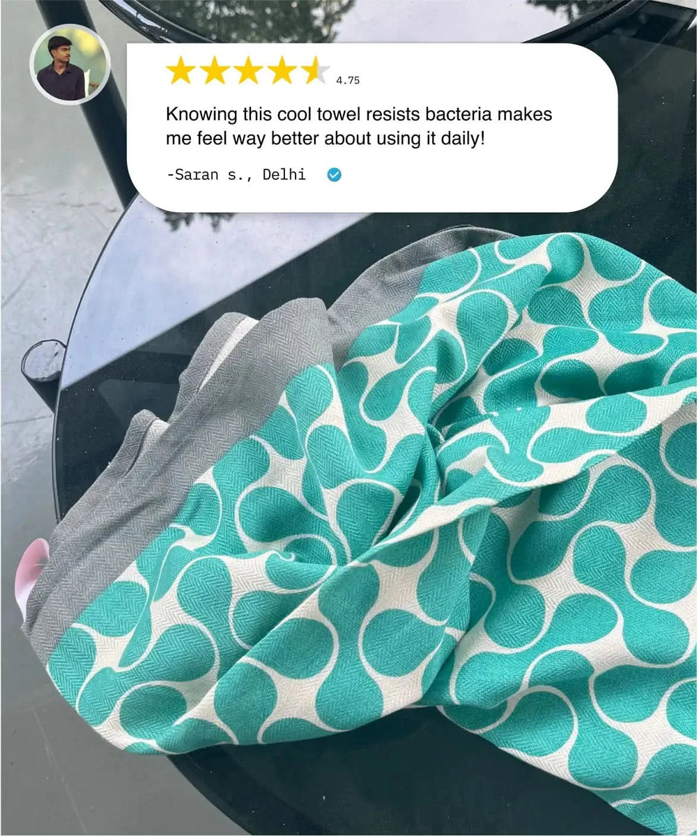 Teal patterned towel with gray border on a car seat, user review above.