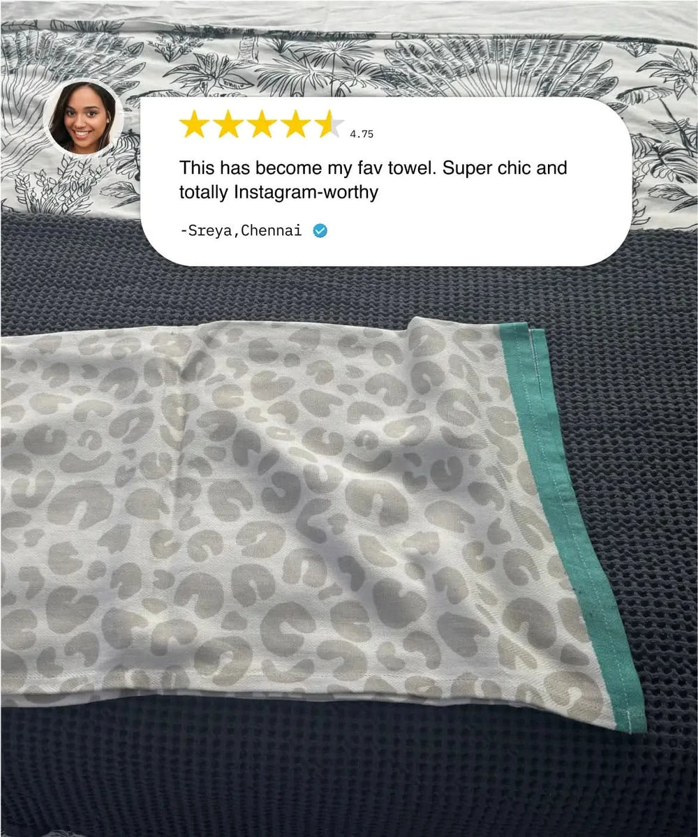 Leopard print towel with green border on a textured surface, featuring a customer review.