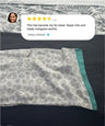 Leopard print towel with green border on a textured surface, featuring a customer review.
