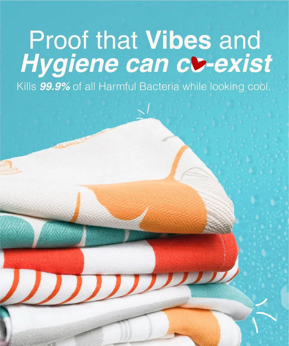 Stack of colorful towels with text about hygiene and bacteria-killing properties on a blue background