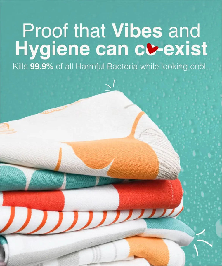 Stack of colorful towels with text about hygiene and bacteria-killing properties on a teal background