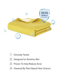 Yellow towel with 'Skin Shield' technology label on a white background